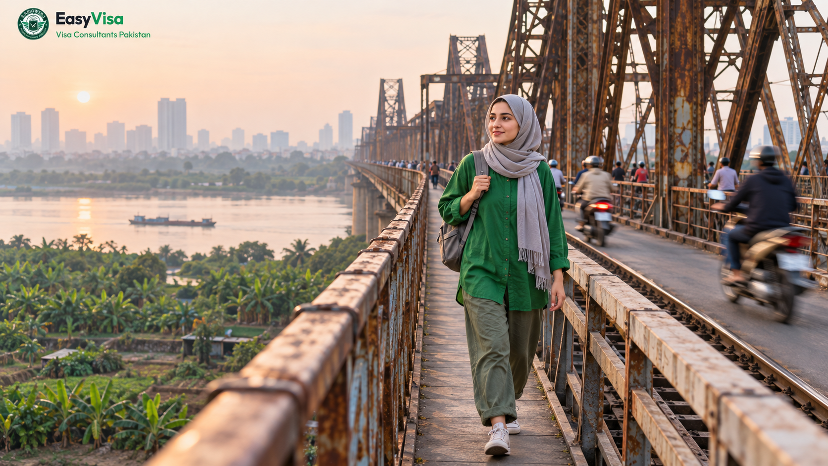 Young Pakistani woman traveller with a backpack walking the pedestrian lane of Long Bien Bridge over the Red River in Hanoi in the morning