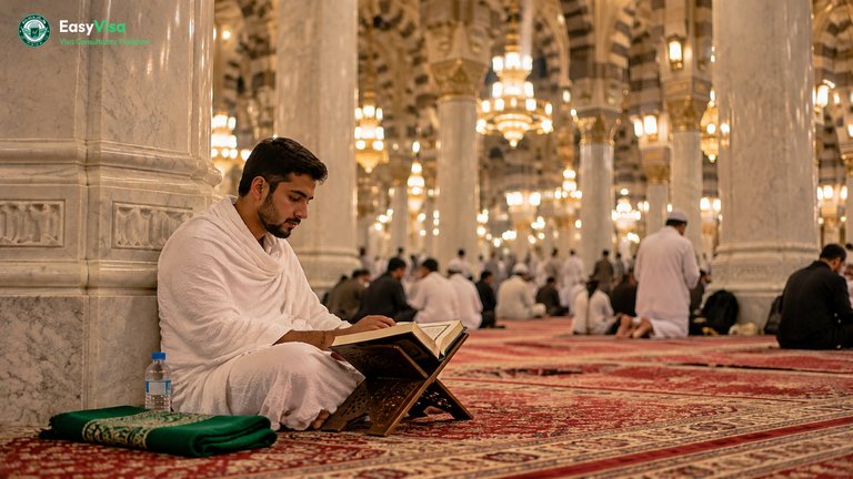 Young Pakistani pilgrim reading the Quran on a wooden stand beside a marble pillar in Masjid al-Haram during the last ten nights of Ramadan