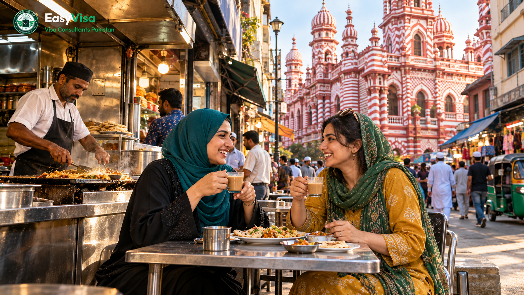 Two Pakistani women friends sharing kottu roti at a busy street eatery in Pettah, Colombo, with the red-and-white Jami Ul-Alfar Mosque behind